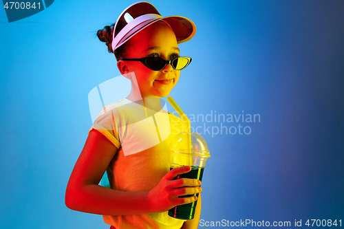 Image of The happy teen girl standing and smiling against blue background.