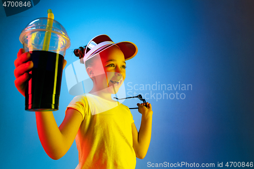 Image of The happy teen girl standing and smiling against blue background.