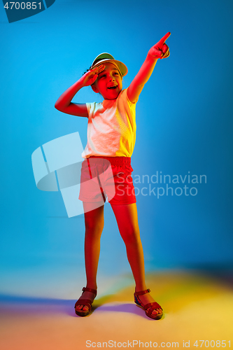 Image of The happy teen girl standing and smiling against blue background.