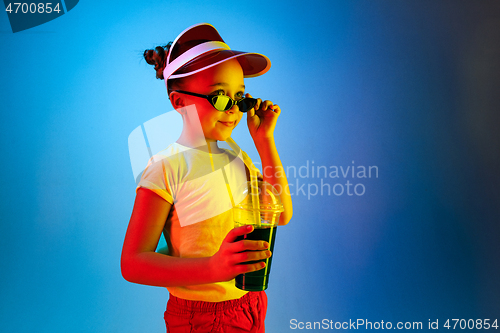 Image of The happy teen girl standing and smiling against blue background.