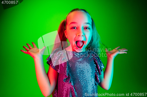 Image of Beautiful teen girl looking suprised isolated on green