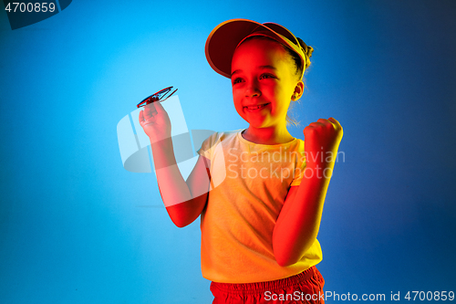 Image of The happy teen girl standing and smiling against blue background.