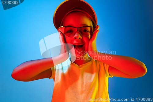 Image of The happy teen girl standing and smiling against blue background.