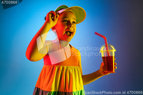 Image of The happy teen girl standing and smiling against blue background.