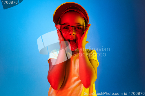 Image of The happy teen girl standing and smiling against blue background.
