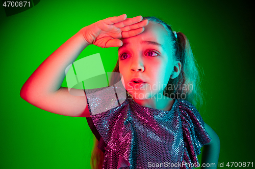 Image of Beautiful teen girl looking suprised isolated on green