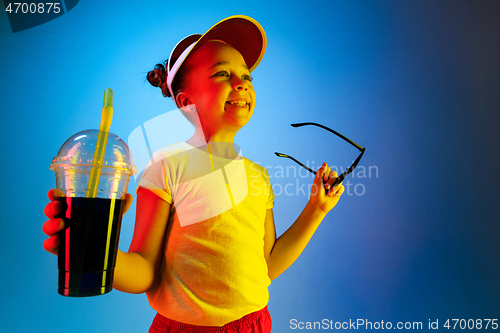 Image of The happy teen girl standing and smiling against blue background.