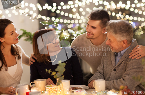 Image of happy family having tea party at home