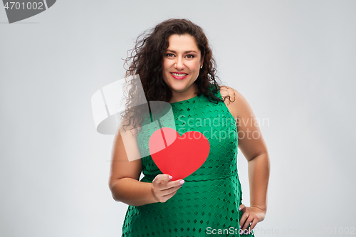 Image of happy woman in green dress holding red heart