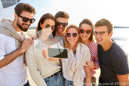 Image of happy friends taking selfie on summer beach