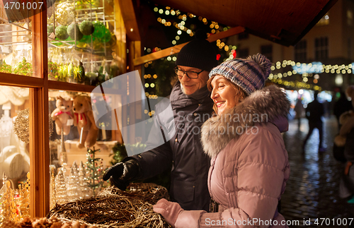 Image of happy senior couple hugging at christmas market