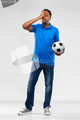 Image of upset indian male football fan with soccer ball