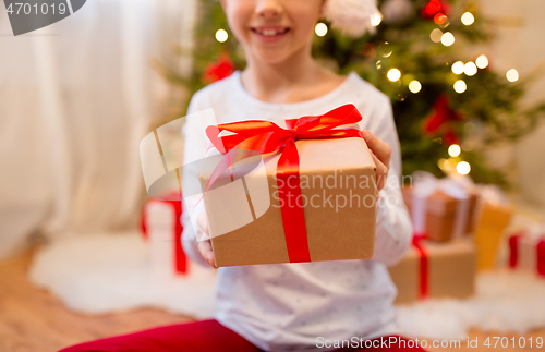 Image of close up of girl with christmas gift at home