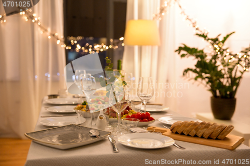 Image of table served with plates, wine glasses and food