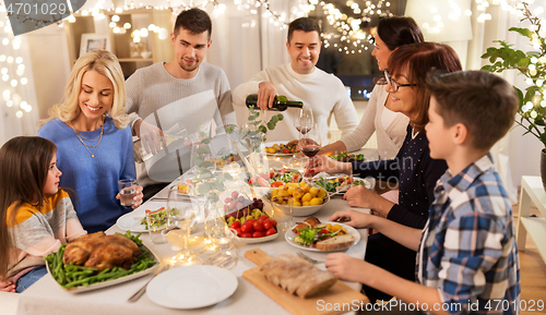 Image of happy family having dinner party at home