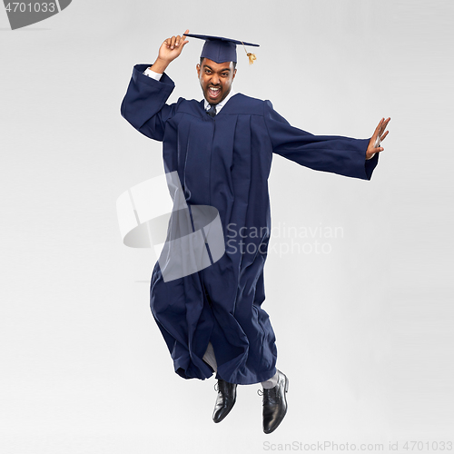 Image of happy male indian graduate student jumping