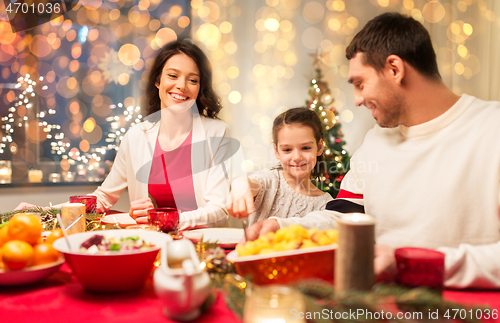 Image of happy family having christmas dinner at home