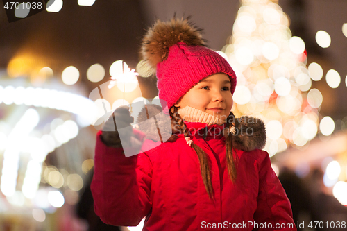 Image of happy girl with sparkler at christmas market