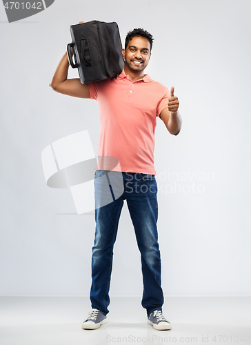 Image of smiling indian man with travel bag on shouder