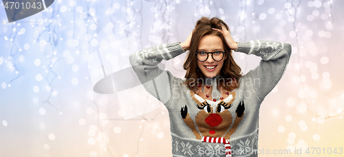 Image of woman in christmas sweater with reindeer pattern