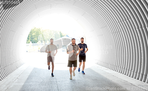 Image of male friends with earphones running outdoors