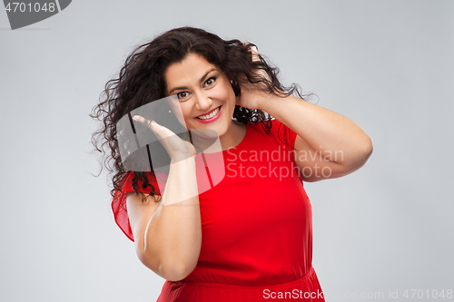 Image of happy woman touching her hair over grey background