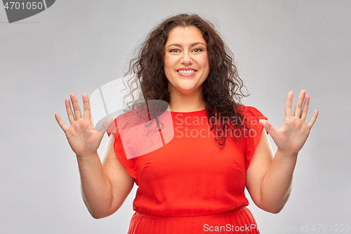 Image of happy woman in red dress showing hand palms