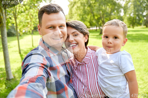 Image of happy family taking selfie at summer park