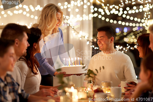 Image of happy family with cake having birthday party