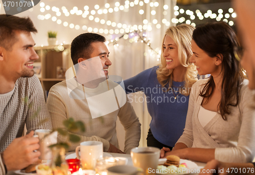 Image of happy family or friends having tea party at home
