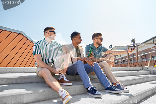 Image of men drinking beer and taking selfie by smartphone