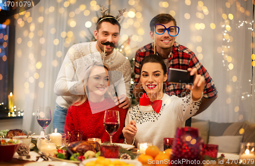 Image of friends taking selfie at christmas dinner