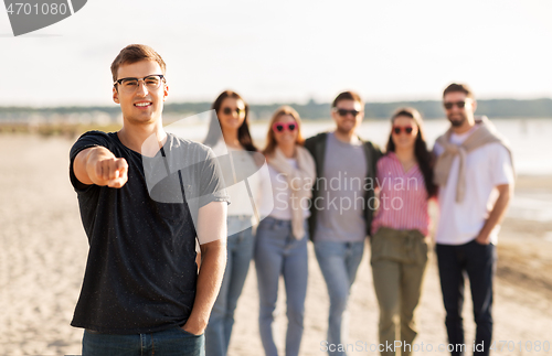 Image of happy man with friends on beach in summer