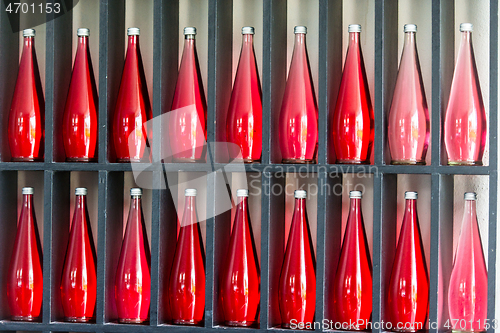 Image of bottles of red juice in modern restaurant