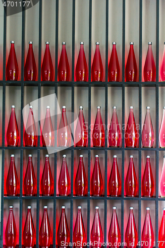 Image of bottles of red juice in modern restaurant