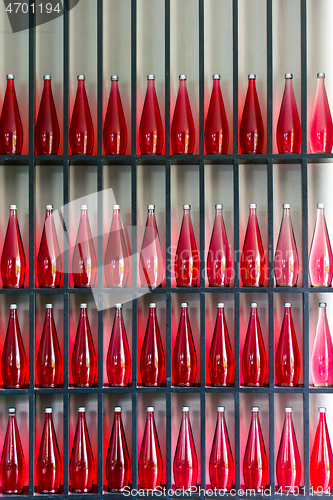 Image of bottles of red juice in modern restaurant