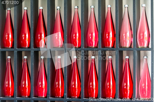 Image of bottles of red juice in modern restaurant