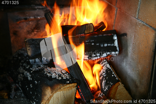 Image of fire with wood in a cast iron stove