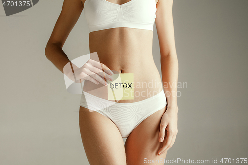 Image of Women belly with drawing word DETOX