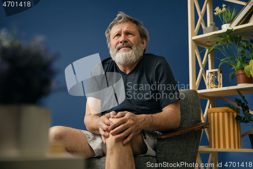 Image of Old bearded man suffering from knee pain