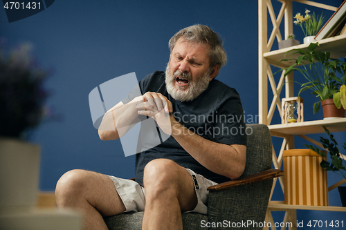 Image of Old bearded man suffering from pain