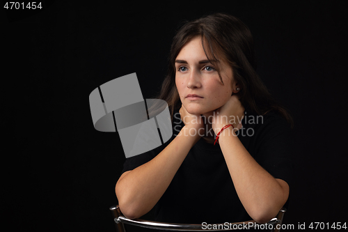 Image of Portrait of a young girl with her elbows on the back of a chair