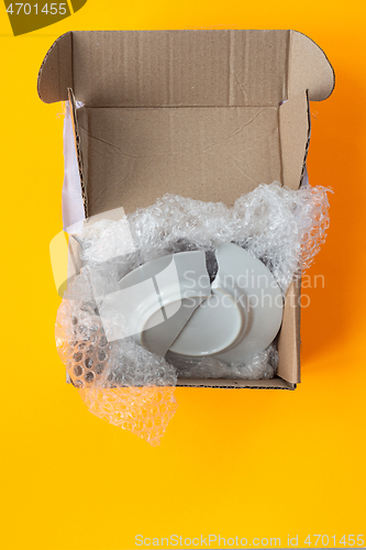 Image of Upon opening, the parcel contained a broken plate, yellow background