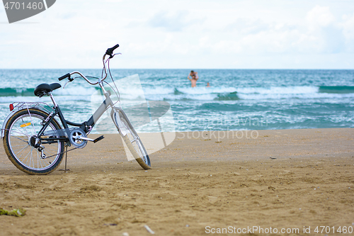 Image of The bike stands on the sandy sea beach