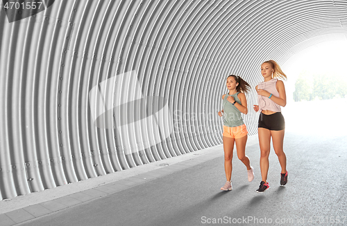 Image of women or female friends with earphones running