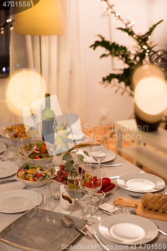 Image of table served with plates, wine glasses and food