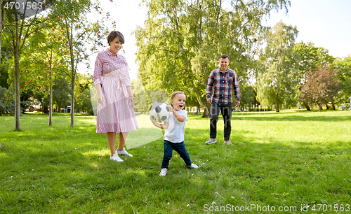 Image of happy family playing soccer at summer park