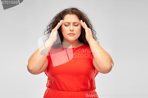 Image of woman in red dress suffering from headache