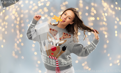 Image of woman in christmas sweater with reindeer pattern