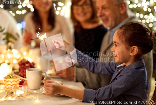 Image of happy girl with sparkler at family tea party